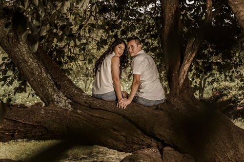 Young Couple Sitting on a Tree
