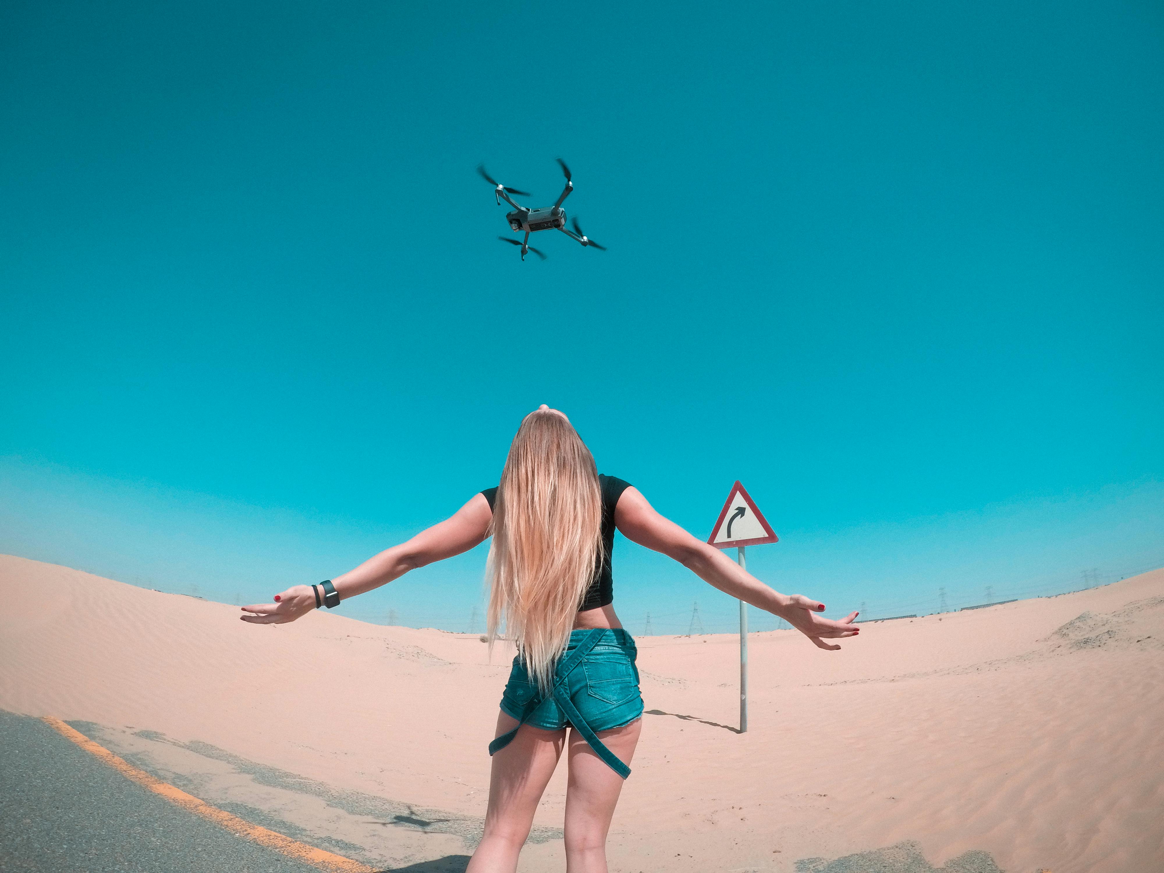 black quadcopter over woman wearing black shirt