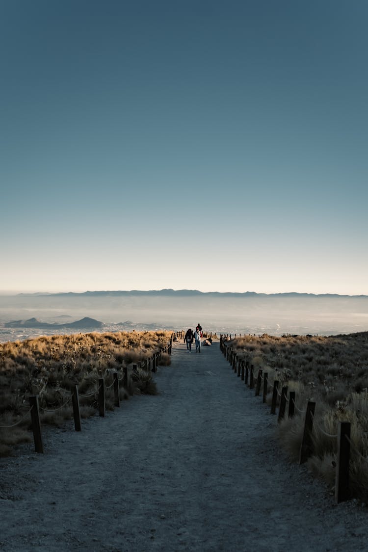 People Hiking On A Trail In Mountains 