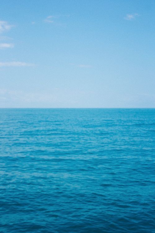 Free Serene and tranquil ocean view under a clear blue sky, perfect for relaxation themes. Stock Photo