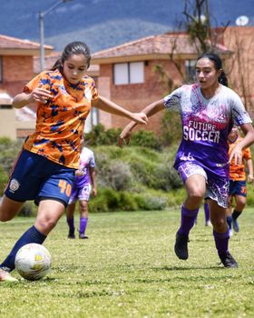 Vibrant action capture of a women's soccer match, showcasing skill and teamwork outdoors.