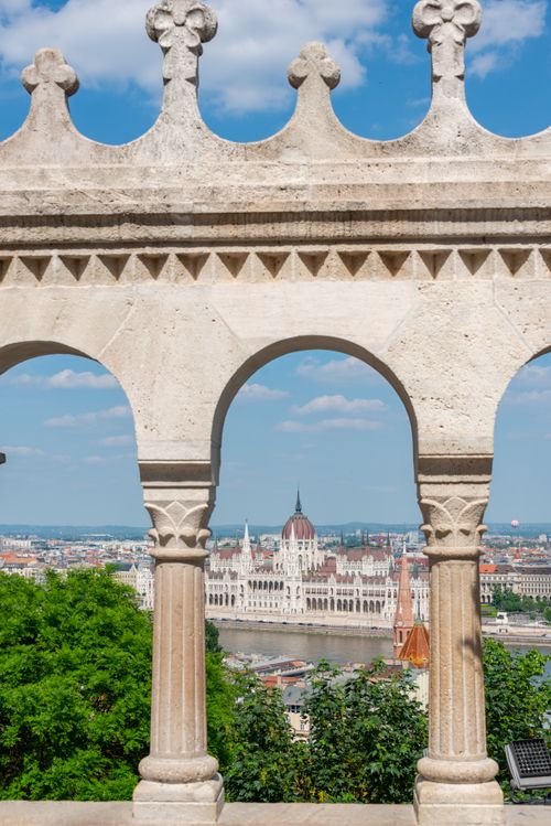 Free View of Budapest's iconic Parliament Building framed by Fisherman's Bastion arches. Stock Photo