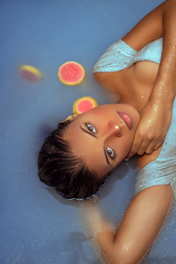 Young Woman Floating On Water Surface 