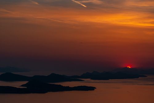 Free Beautiful sunset over a calm sea with silhouetted islands, creating a tranquil seascape. Stock Photo