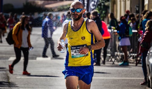 Man in Yellow and Blue Tank Top Running