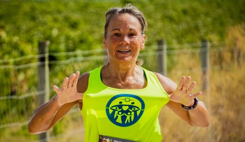 Free Energetic senior woman running outside, promoting health and fitness. Stock Photo