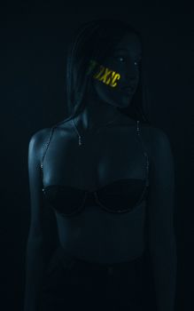 Dramatic portrait of a woman in lingerie with neon light projection.