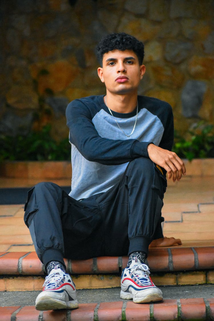 Handsome Man In Sweatshirt Sitting On Step