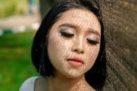 一名女子的户外特写肖像，脸上映着艺术栅栏的阴影