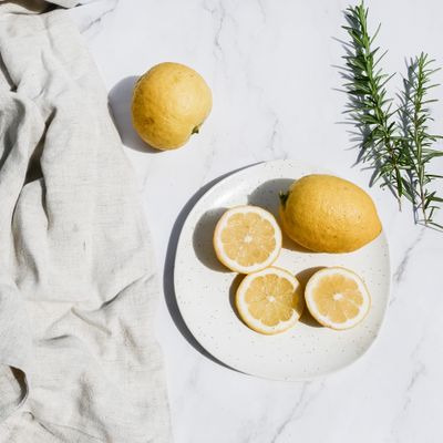 Fresh lemons on a white plate — photo by Studio Naae on Pexels