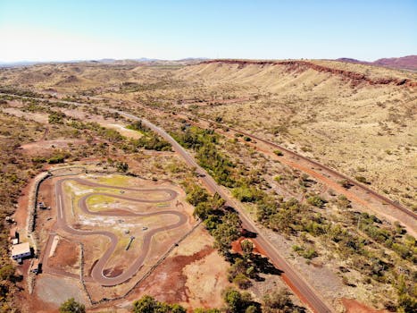 Aerial drone view of a scenic arid landscape with a winding road in Tom Price, Western Australia.