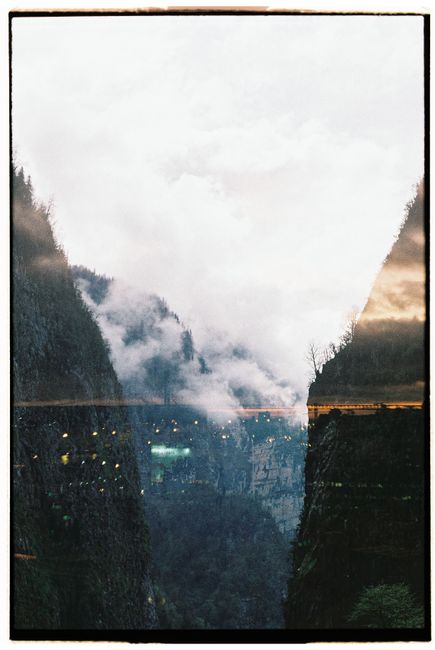 Scenic canyon view with dramatic overcast clouds and reflections in a vertical frame.