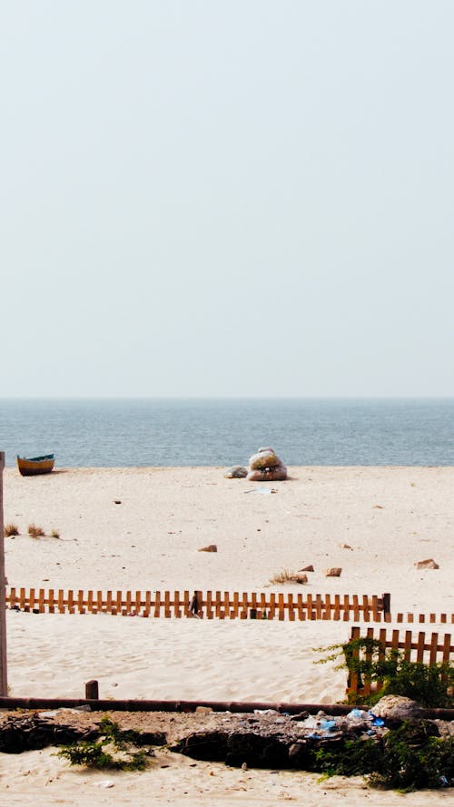 View of a Small Wooden Fence on a Beach and Sea in the Background 