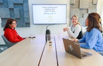 Women Sitting at a Table in a Boardroom and Talking