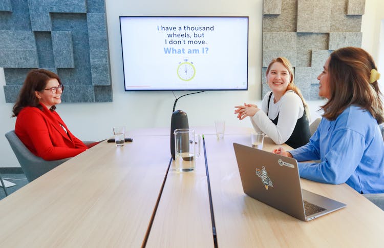 Women Sitting At A Table In A Boardroom And Talking 