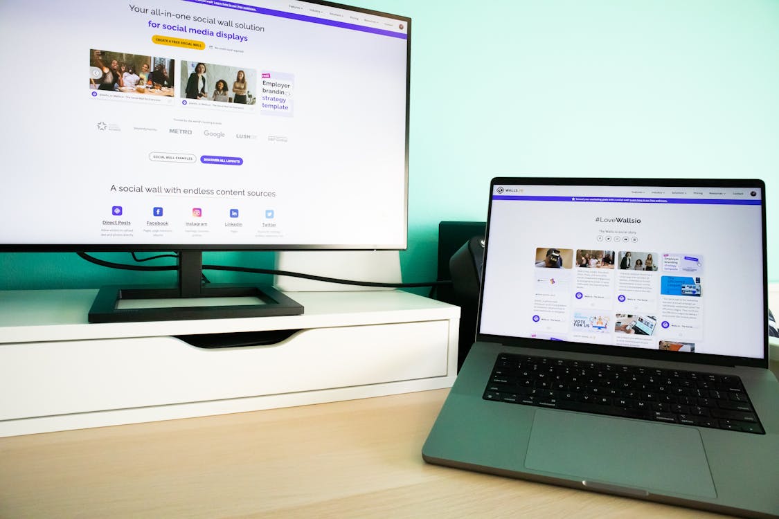 Free A Desk with a Laptop and Monitor Displaying Websites  Stock Photo