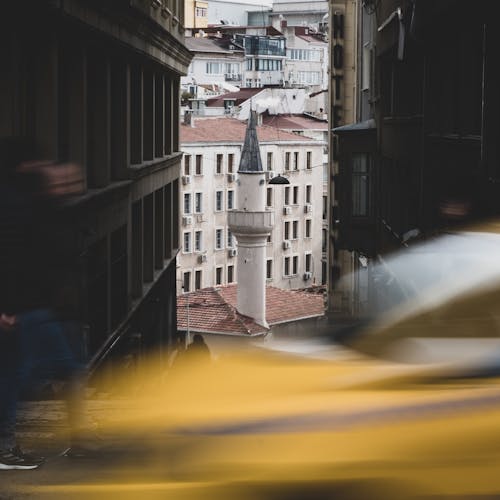 Blurred Taxi and Man near Minaret in Town