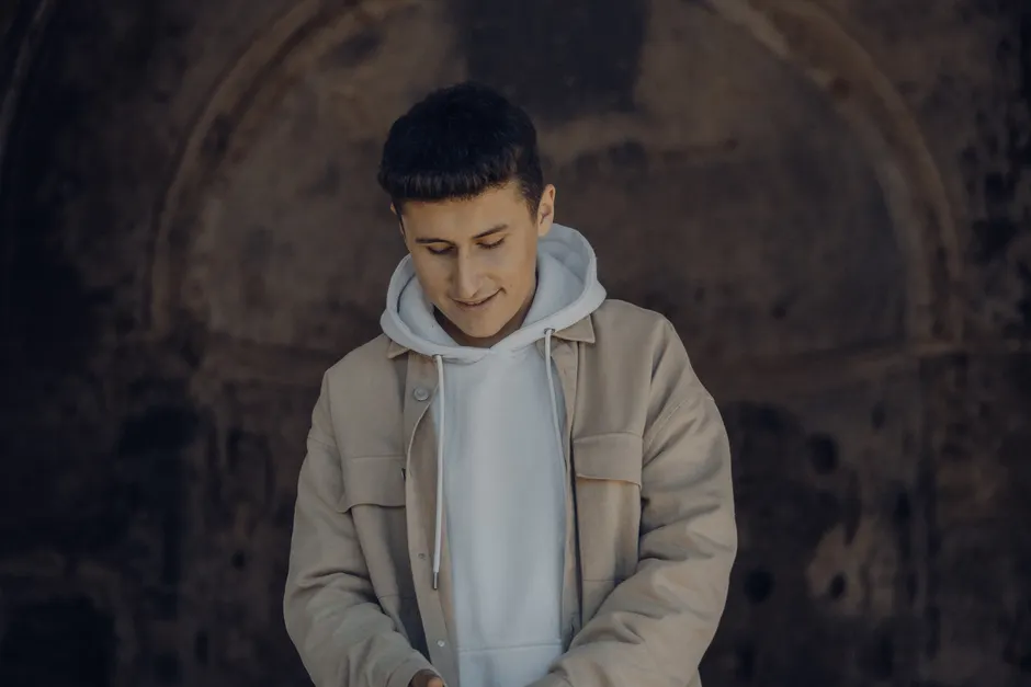 Homme en sweat à capuche blanc sous une veste beige, look streetwear urbain élégant
