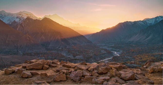 Captivating view of a sunrise illuminating a rugged mountain valley, showcasing natural beauty and tranquility.