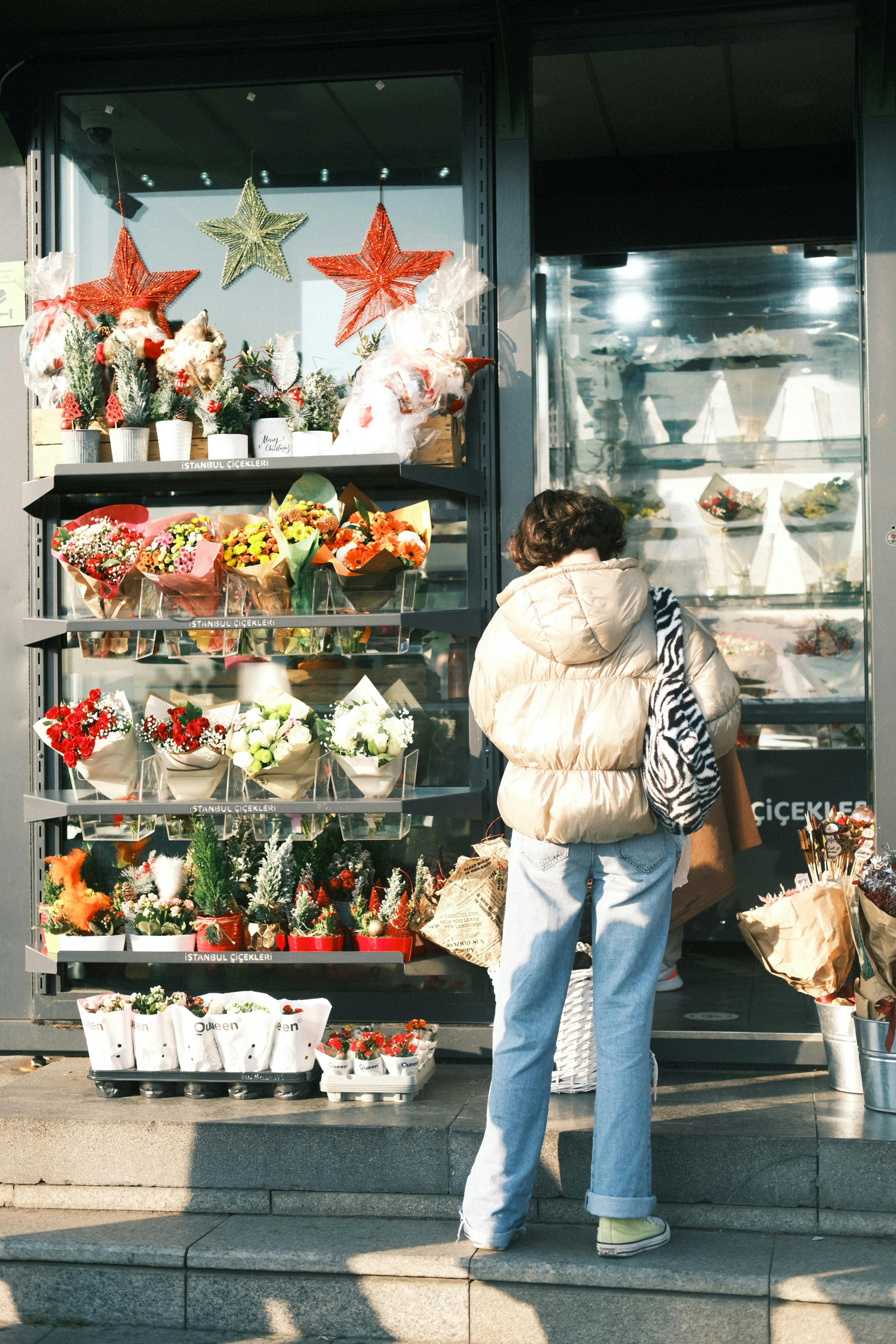 A woman buying flowers at an urban florist shop, showcasing colorful blooms.