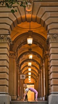 Woman practicing yoga under Sydney's iconic archways at Martin Place.