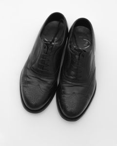 A pair of elegant black leather shoes displayed against a white background.