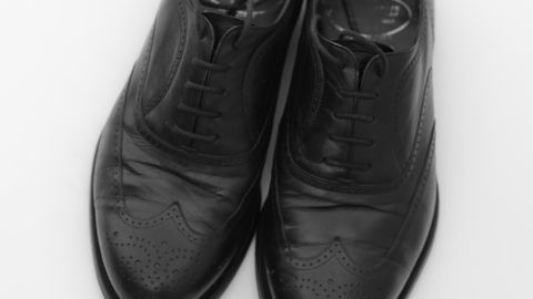 A pair of elegant black leather shoes displayed against a white background.