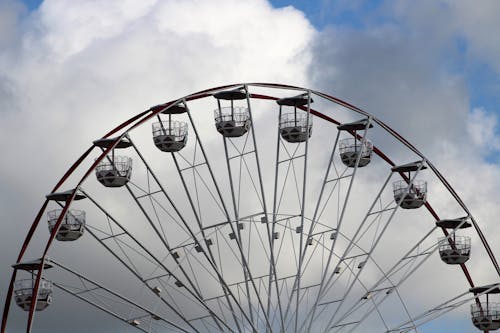 Top of Ferris Wheel against Cloudy Sky