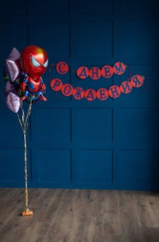 Vibrant Spiderman balloon and Russian birthday banner against a blue wall.