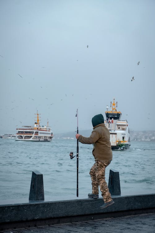 Man with Fishing Rod on Sea Shore 