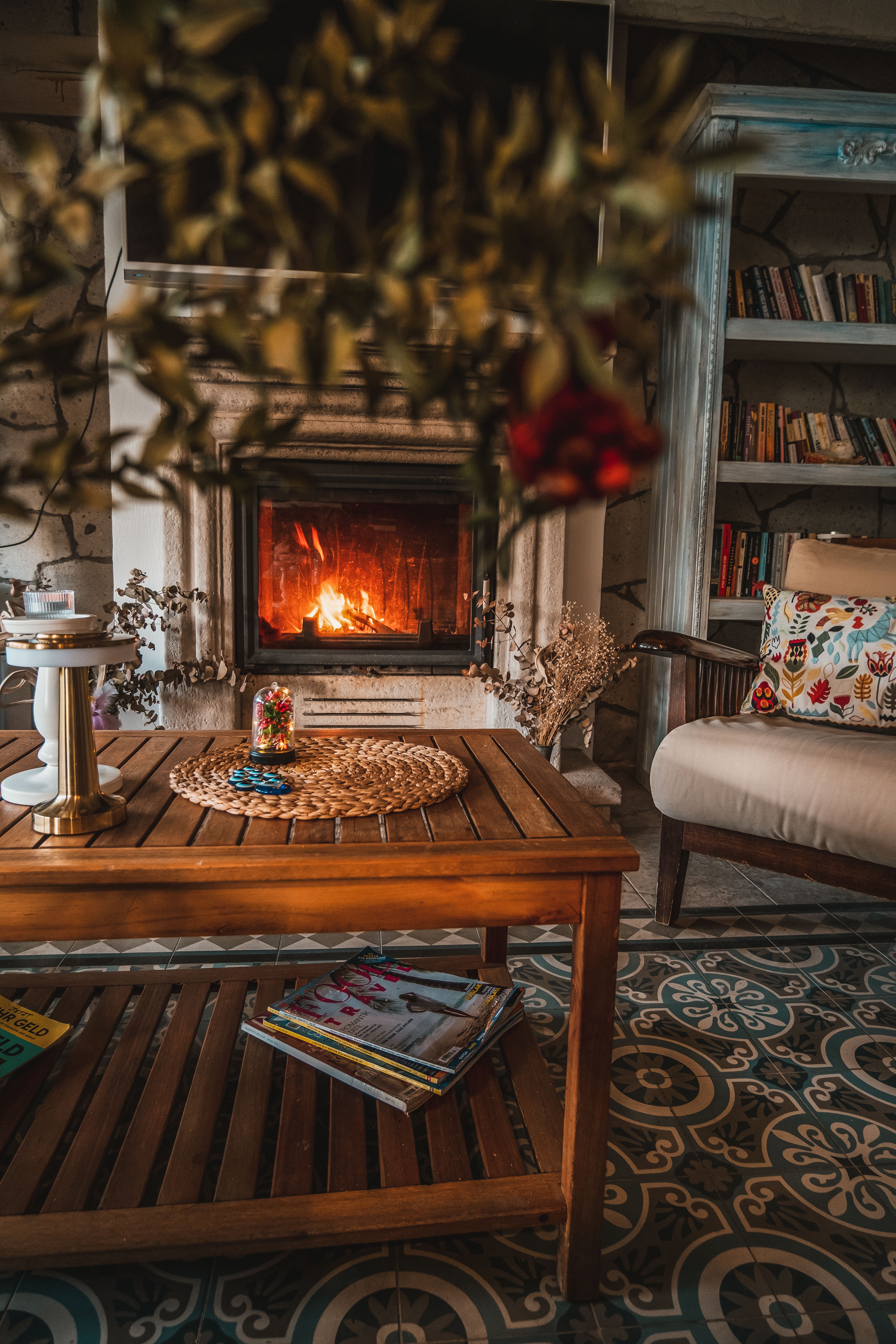 Warm and inviting living room featuring a lit fireplace, comfy chair, and homey decor.
