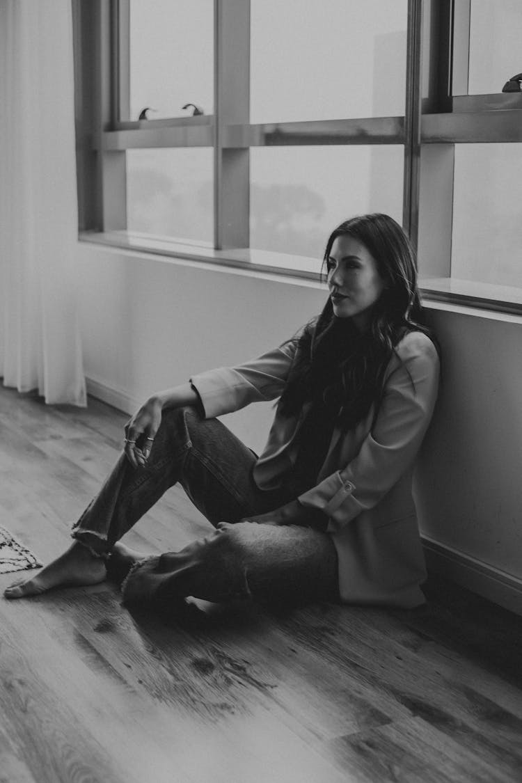 Black And White Shot Of A Woman Sitting On The Floor 