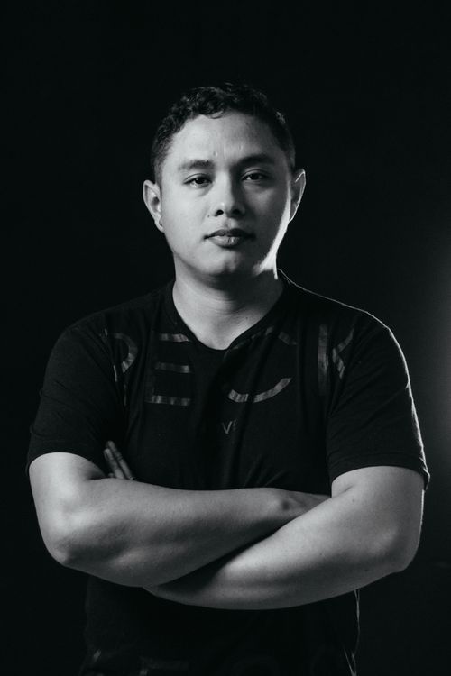 Free Captivating black and white portrait of a man standing confidently with crossed arms in a studio setting. Stock Photo