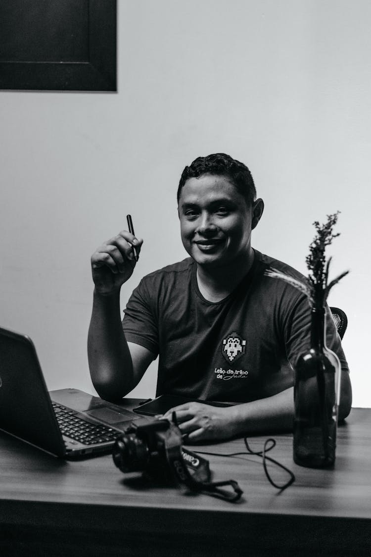 Man At Desk With Laptop And Camera