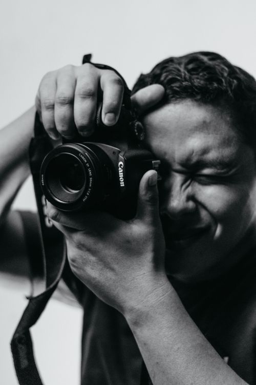 Free Black and white portrait of a man concentrating, capturing a moment with a camera. Stock Photo