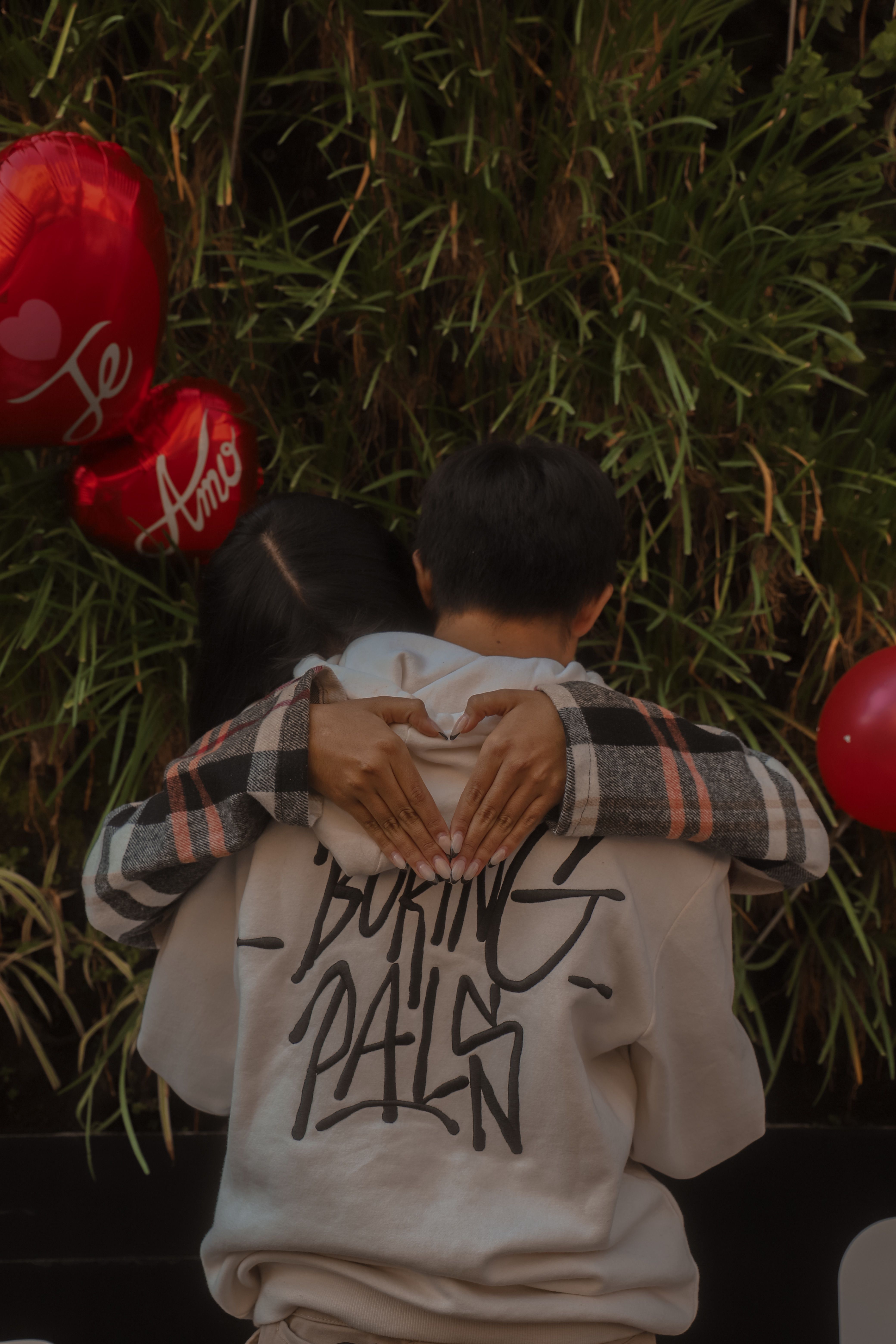 Woman Hands Hugging Man on Grass with Balloons with Te Amo Text around ...