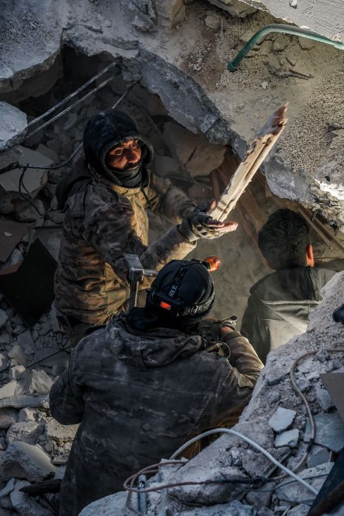 Free Rescuers clearing debris to save trapped individuals in Jindires, Suriye. Stock Photo