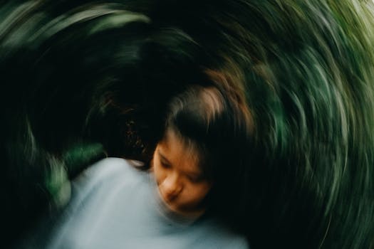 Artistic blurred motion portrait of a young woman outdoors with abstract swirling effect.