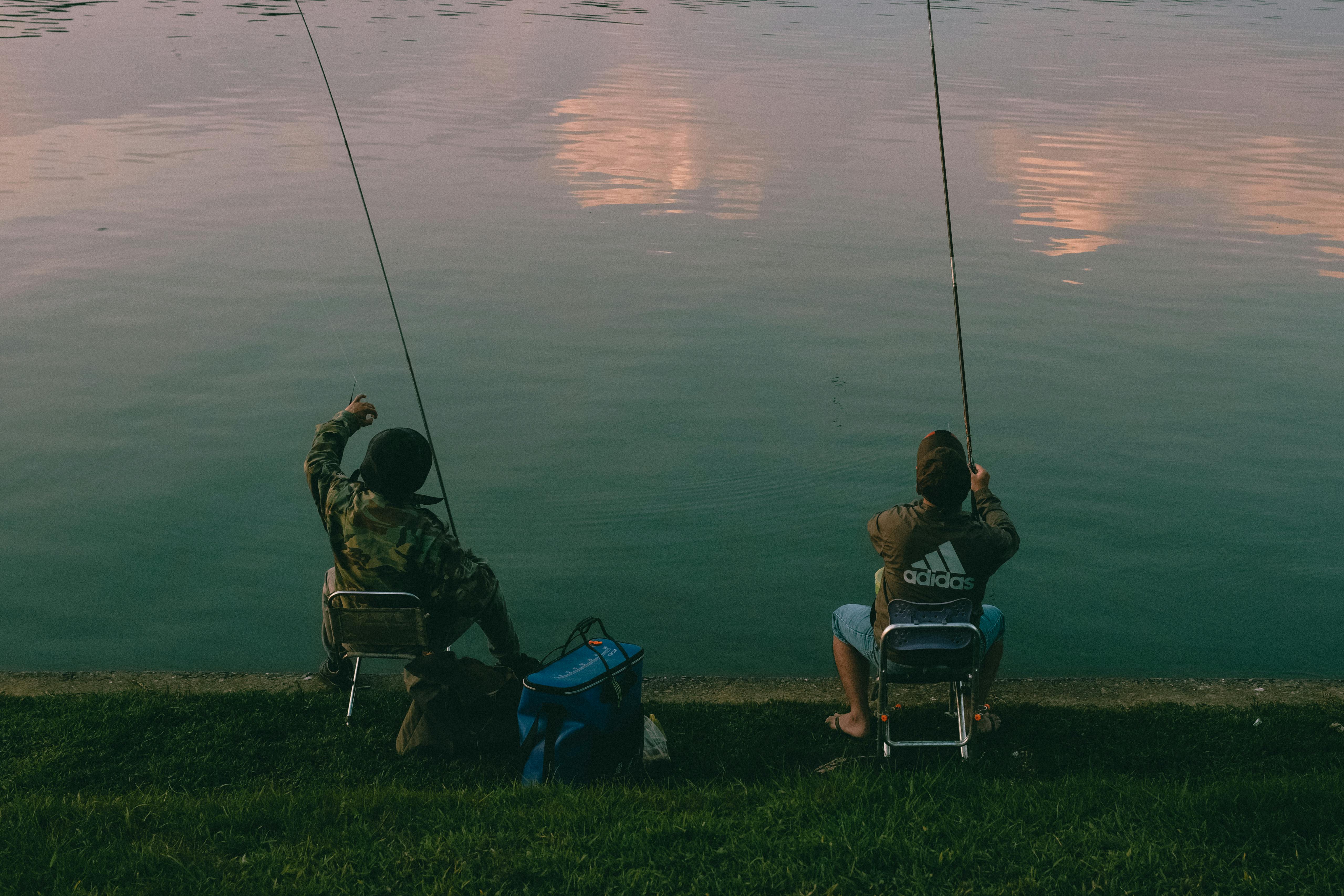 Two People Sitting with Fishing Rods · Free Stock Photo