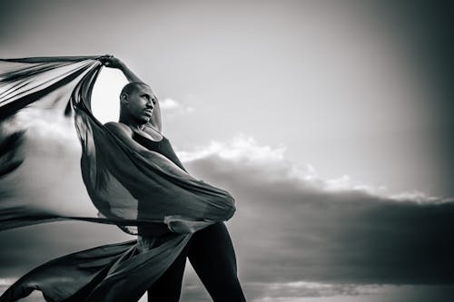 Woman Posing with Arm Raised and Holding Fabric in Black and White