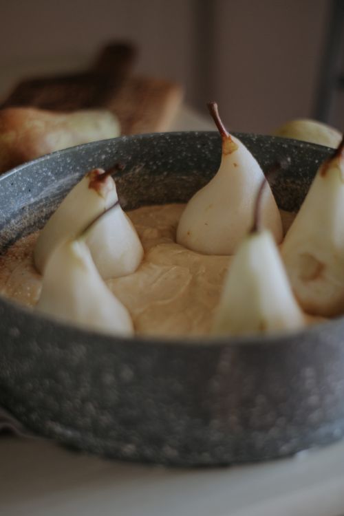 Free Close-up of a homemade pear cake in a rustic baking pan with natural lighting. Stock Photo