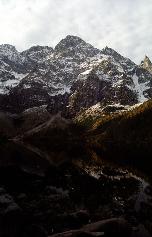 Free Stunning view of a snowcapped mountain with reflection in the valley below, creating a dramatic landscape. Stock Photo