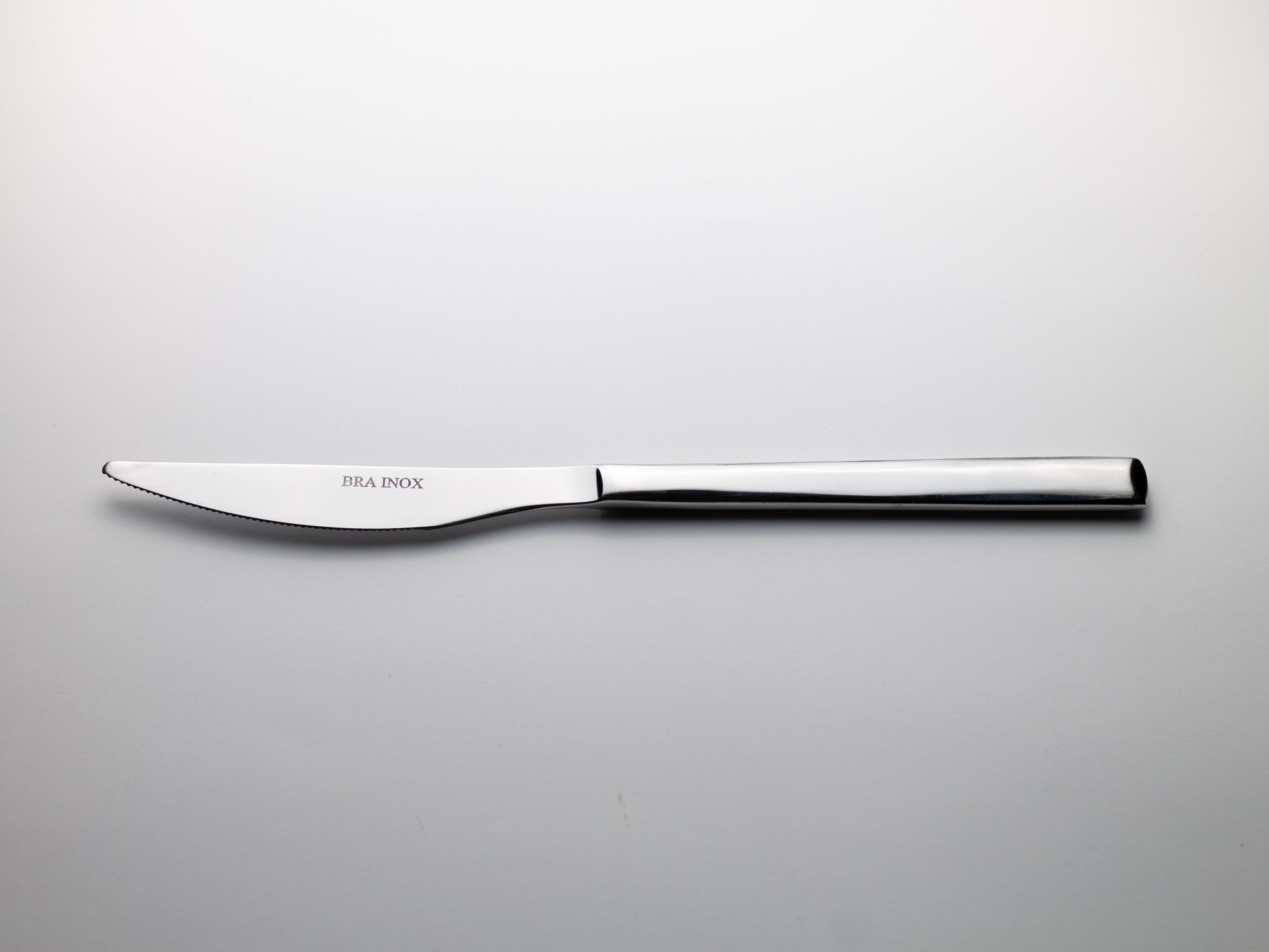 Simple and elegant stainless steel knife on a plain background.