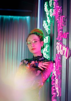 Fashion portrait of a woman with eyeglasses in neon lighting, modern vibe.