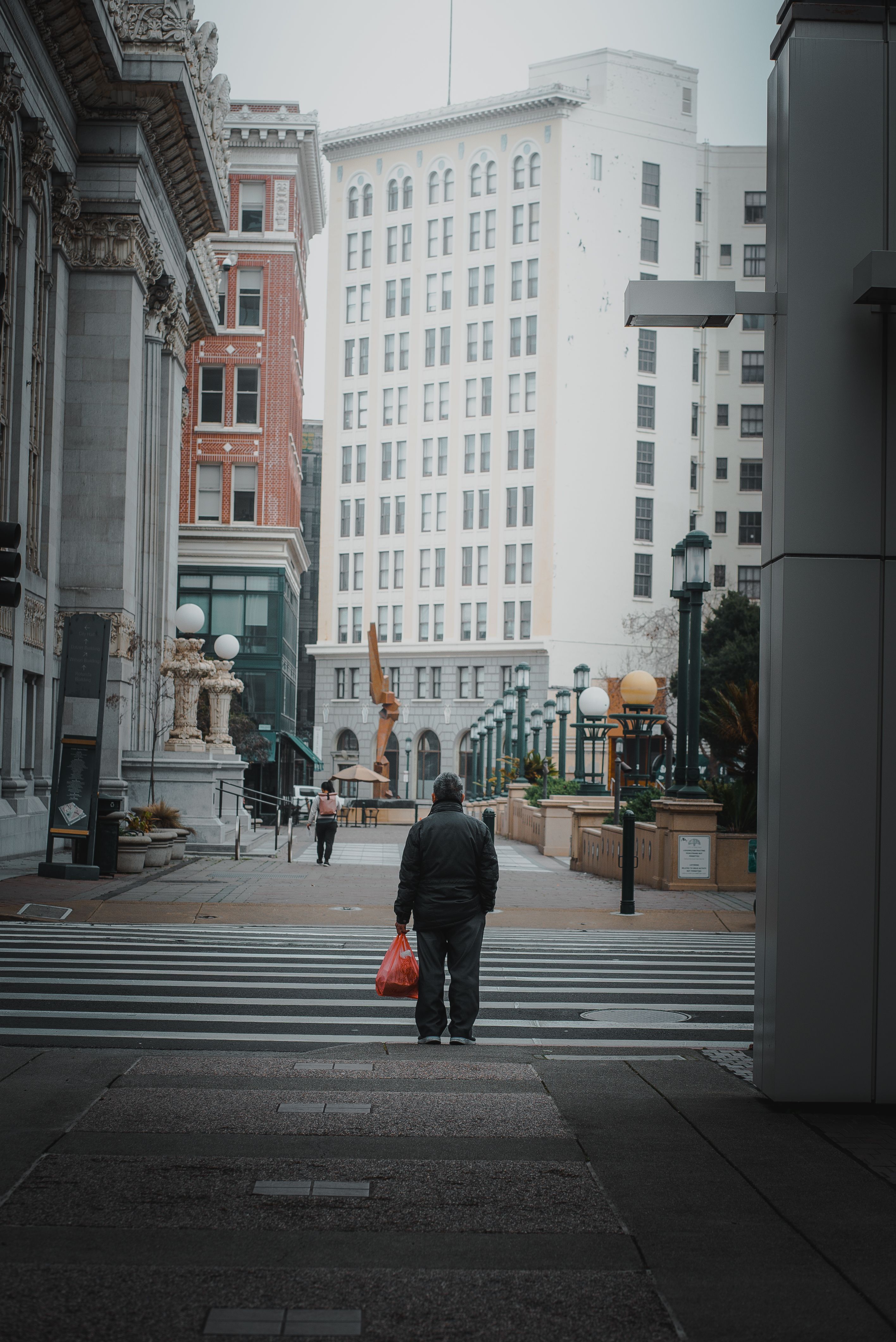 A person walking down a city street with a red bag · Free Stock Photo