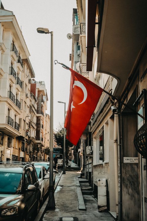 Free Narrow street in Istanbul adorned with the Turkish flag, showcasing urban architecture and local culture. Stock Photo