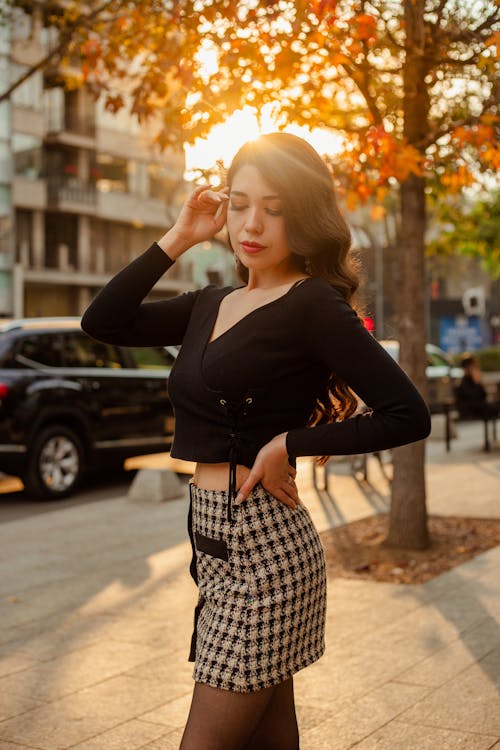 Woman Standing on Street Illuminated by Setting Sun