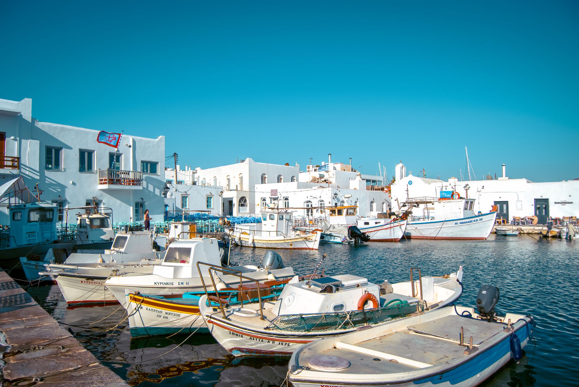 Parikia port in Paros with traditional Greek buildings and boats in the harbor