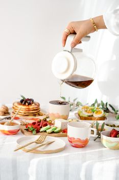 A beautifully arranged breakfast table featuring pancakes, coffee, and a variety of breakfast items for a delightful morning meal.