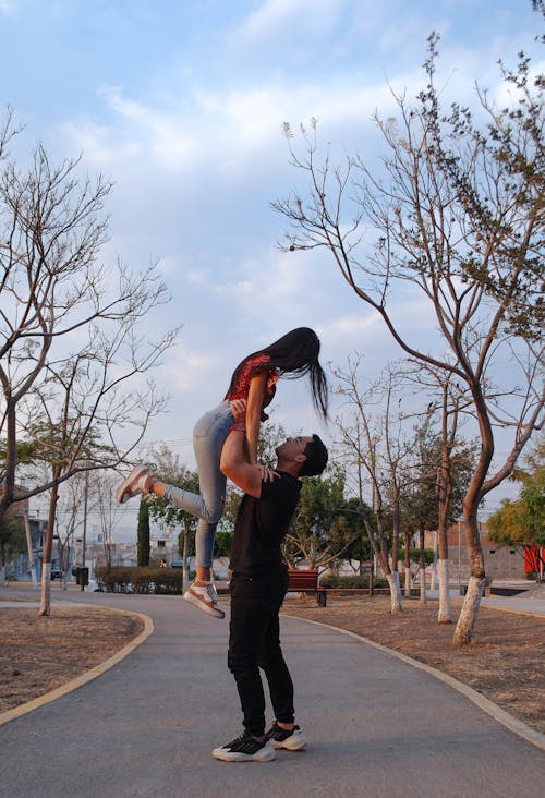 Man Raising Woman Up on Park Alley